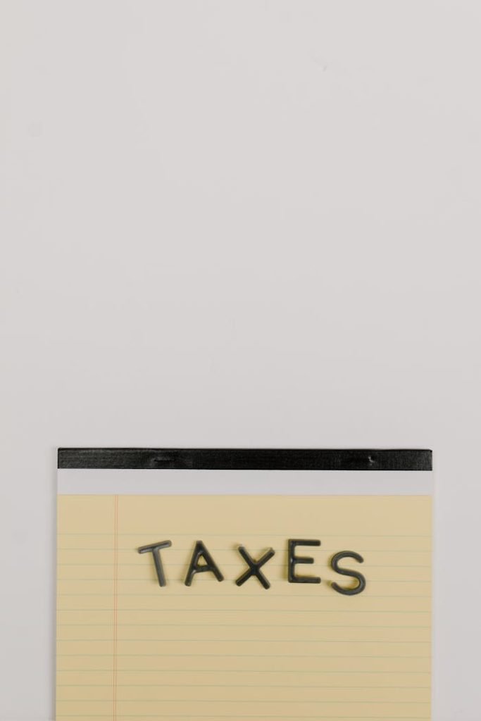 Notepad with the word Taxes on a white background, ideal for finance themes.