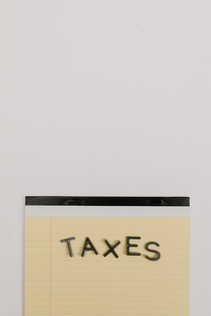 The Art of Drawing Readers In: Your attractive post title goes here Notepad with the word Taxes on a white background, ideal for finance themes.